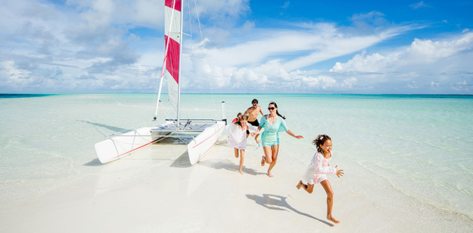 Семья наслаждается пляжем на Мальдивах