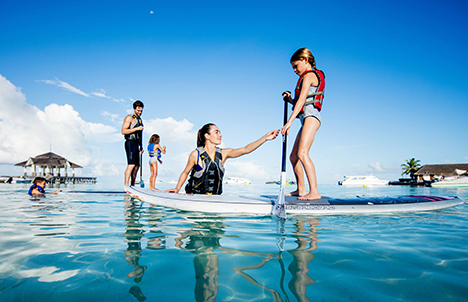 Kids Learning Paddle Boarding in Maldivian Waters